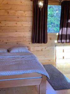 a bedroom with a bed in a wooden wall at Vikendica Pavle in Trebinje
