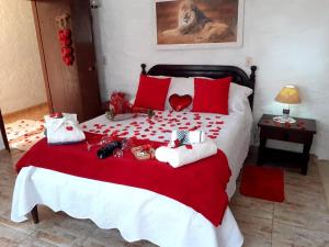 un letto rosso e bianco con sopra animali di peluche di Chalé pinheiro velho a Monte Verde