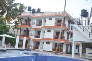 a building with a swimming pool in front of it at Nikhil Residence in Varkala