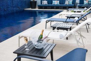 a pool with a table with two bottles of wine and glasses at Golden Tulip Porto Vitória in Vitória