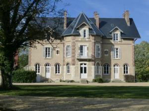 una grande casa in mattoni con tetto nero di Gite la chaumière Le chateau de la Brosse a Brinay