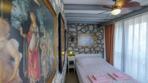 a bedroom with a bed and a painting on the wall at Teras butik apart in Karaburun