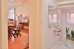 a kitchen with a table and a sink in a room at Vila Santa Eulalia Hostel in Pelotas +56 photos