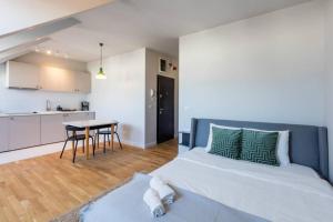 ein Schlafzimmer mit einem Bett und eine Küche mit einem Tisch in der Unterkunft Vivando - Scandic Studio F + Parking in Bukarest