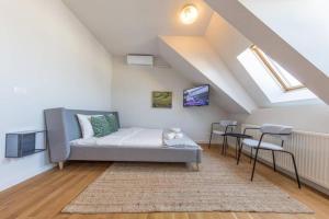 een kamer met een bed en stoelen op een zolder bij Vivando - Scandic Studio F + Parking in Boekarest