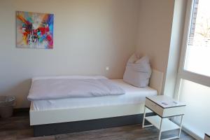 a small bedroom with a bed and a table at City Pension Stadtlohn in Stadtlohn