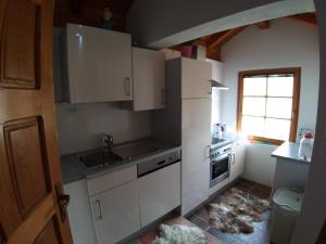 a kitchen with white cabinets and a sink and a window at COUNTRY HOUSE in Bihać