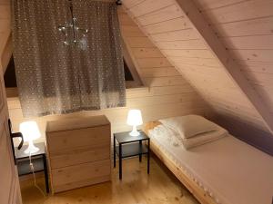 1 dormitorio con 1 cama y 2 mesitas de noche en Nad Zalewem - Kluczbork- domki całoroczne, en Ligota Zamecka
