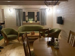a living room with green chairs and a table at Nad Zalewem - Kluczbork- domki całoroczne in Ligota Zamecka