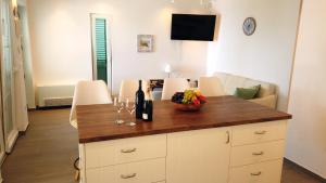 een keuken met een aanrecht met een schaal fruit en wijnglazen bij Beach House Ana in Sukošan