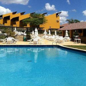 een groot blauw zwembad met stoelen en een gebouw bij Winterville Resort Flat 910 Gravatá-Pe in Gravatá