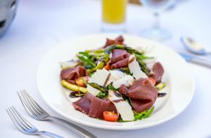 a plate of food with meat and vegetables on a table at The Cove Rotana Resort - Ras Al Khaimah in Ras al Khaimah