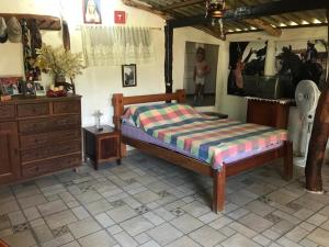 a bedroom with a bed and a dresser and a mirror at Rancho do Paollo in Pirenópolis +23 photos