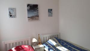 a bedroom with a bed and three pictures on the wall at Le clapotis de l'Ô, calme, balcon sur la mer, à 2 h de Paris in Ault
