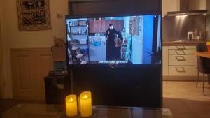 a television screen with two yellow candles in a living room at Vakantiebungalow De Schaapskooi in Epe