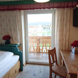 sypialnia z łóżkiem, biurkiem i oknem w obiekcie Alpenhostel "Das Besenhaus" w mieście Altenmarkt im Pongau