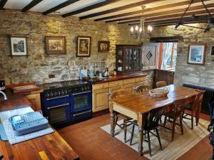 a kitchen with a wooden table and a blue oven at Pathways Cottage in Higham