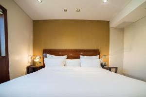 a bedroom with a large bed with white pillows at Windsor Hotel in Córdoba