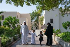 a muslim family walking down a street at The Cove Rotana Resort - Ras Al Khaimah in Ras al Khaimah