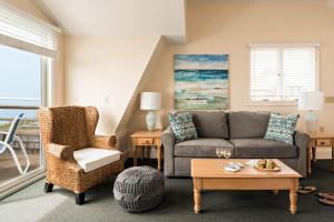 sala de estar con sofá y silla en Chatham Tides, en South Chatham