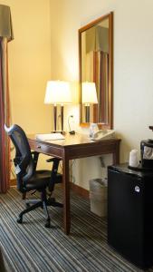 a desk in a hotel room with a chair and a mirror at Holiday Inn Express Turlock, an IHG Hotel in Turlock