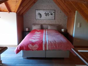 a bedroom with a red bed in a attic at Vakantiehuisje 't Morehof in Oosterzele