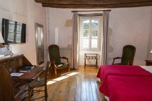 a bedroom with a bed and a desk and a window at Relais de la Mothe in Yzeures-sur-Creuse