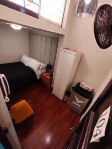 Habitación pequeña con cama y nevera. en Casita Libertad Barranco, en Lima