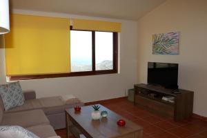 een woonkamer met een bank en een flatscreen-tv bij Amathianis in Triopetra