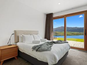 Un dormitorio con una cama grande y una ventana grande. en Sicilian Luxury Retreat, en Queenstown
