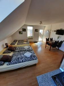 three beds in a room with a table and chairs at Apartmany Star in Liptovský Mikuláš