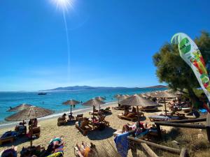 a beach filled with people sitting on chairs at Manios Suites in Agia Anna Naxos