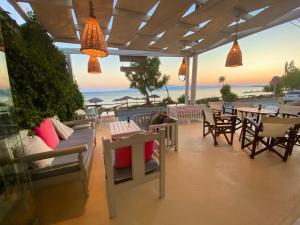 a patio area with tables, chairs, and tables with umbrellas at Manios Suites in Agia Anna Naxos