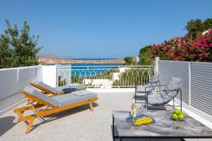 a patio with a couch and a table and chairs at Lindos Shore Junior Suite in Líndos