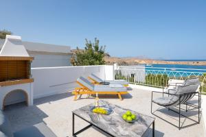 a patio with a couch and chairs and a table at Lindos Shore Junior Suite in Líndos