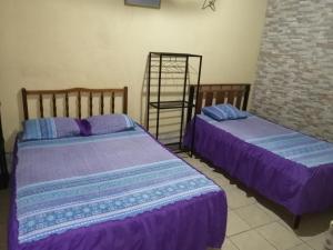 two beds sitting next to each other in a room at La Posada De Don Jose in Flores