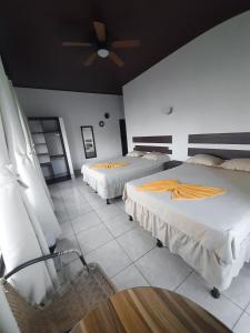 1 dormitorio con 2 camas y ventilador de techo en La Posada De Don Jose, en Flores