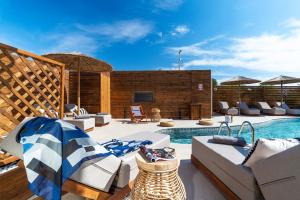 um pátio com uma piscina e cadeiras e uma piscina em Oasis Hotel Prasonisi em Prasonisi