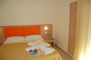 a bedroom with a bed with an orange headboard at Hotel Massimo in Cervia