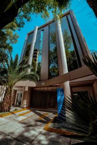 ein Gebäude mit Palmen davor in der Unterkunft Suites Arquimedes 33 in Mexiko-Stadt