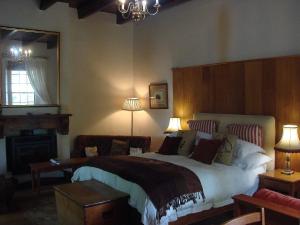 a bedroom with a large bed and a mirror at Die Waenhuis Guest House in George
