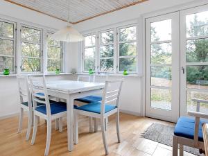 a white dining room with a white table and chairs at 5 person holiday home in V ggerl se in Marielyst