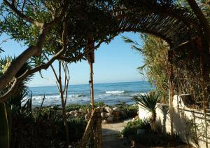 an archway at the beach with the ocean in the background at U scrusciu du mari - Casuzze SeaSound Holidays in Marina di Ragusa