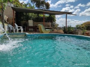 a large pool of water in front of a house at Pousada Cantinho do Dodó in Mulungu