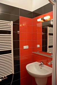 a red bathroom with a sink and a mirror at Just BE that´s enough!! in Prague