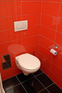 a red bathroom with a toilet in a red wall at Just BE that´s enough!! in Prague