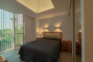 ein Schlafzimmer mit einem Bett und einem großen Fenster in der Unterkunft Suites Arquimedes 33 in Mexiko-Stadt