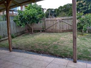 a backyard with a wooden fence and a yard at Casa Refúgio Praia Brava in Itajaí