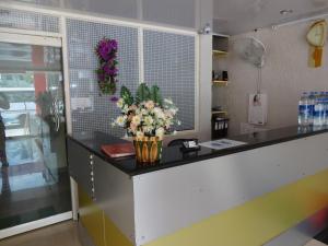 a counter with a vase of flowers on it at Marwa Inn in Trivandrum