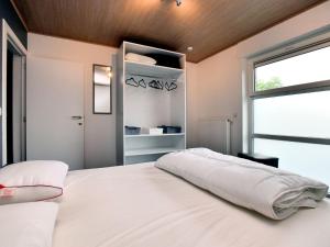 a bedroom with a large white bed with a window at Luxurious Home with Sauna in Somme-Leuze